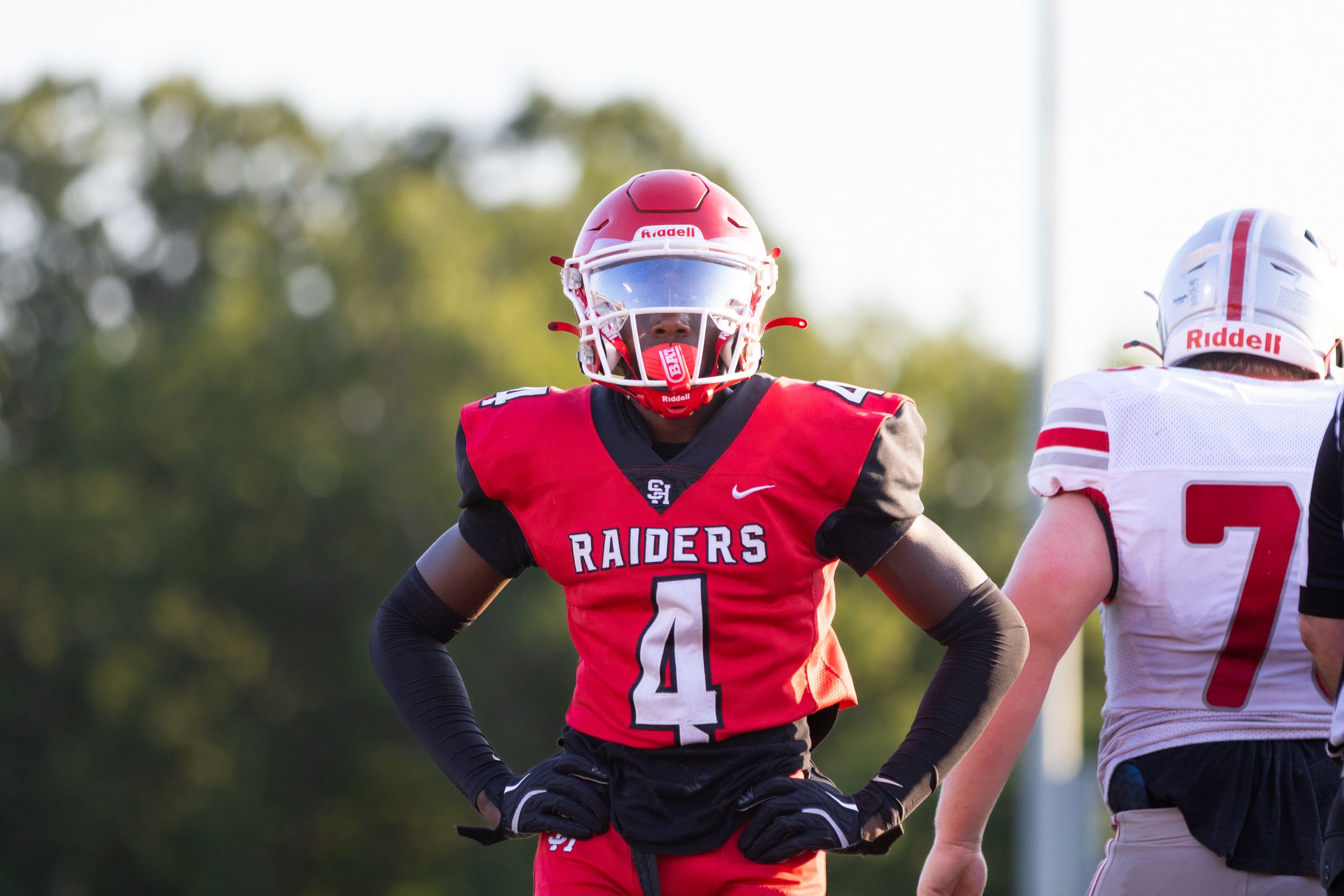 Football player #4 in red Raiders uniform stands on field during a game.