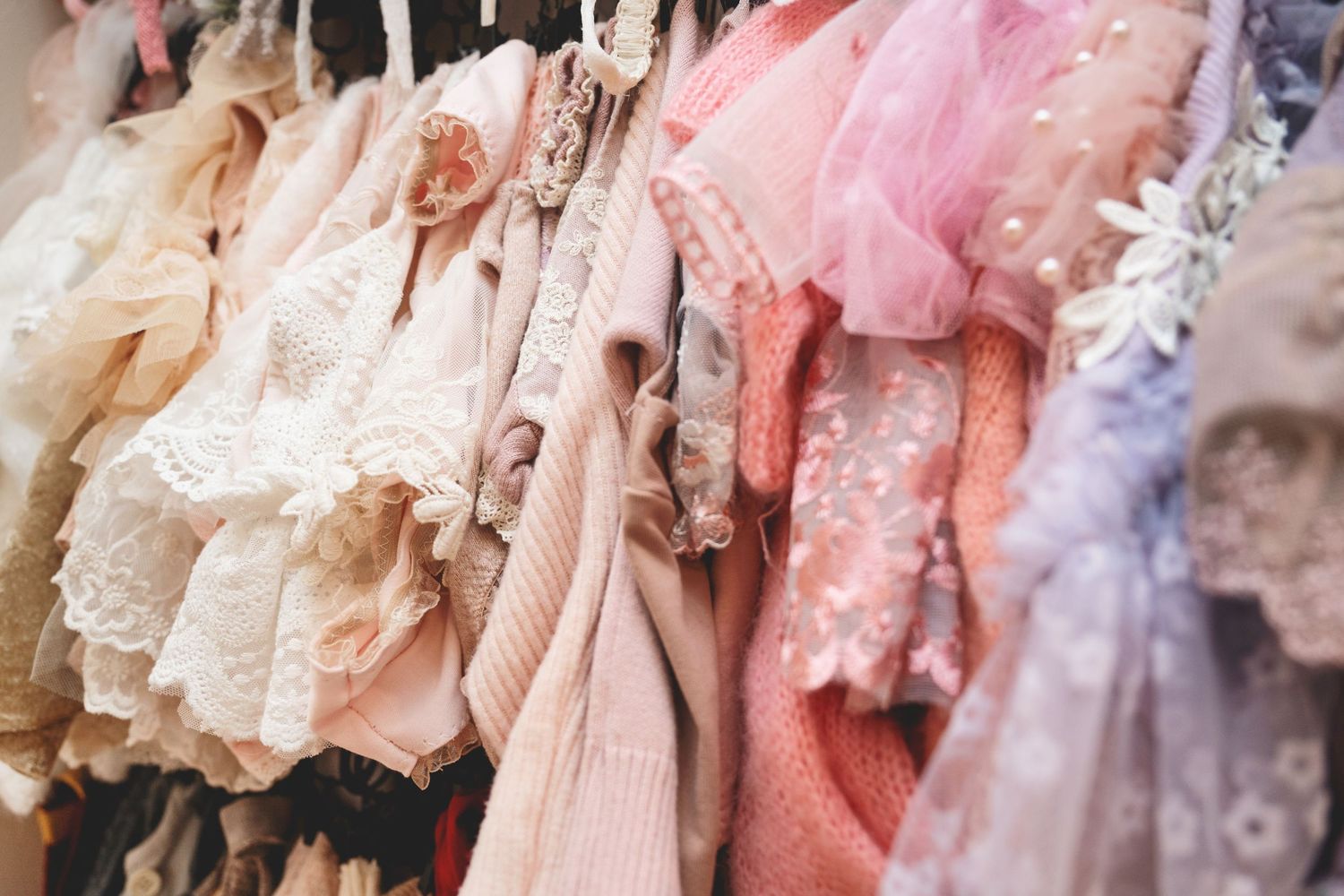 Curated client closet with maternity gowns, newborn outfits, and milestone wardrobe pieces in a Linden, New Jersey photography studio.