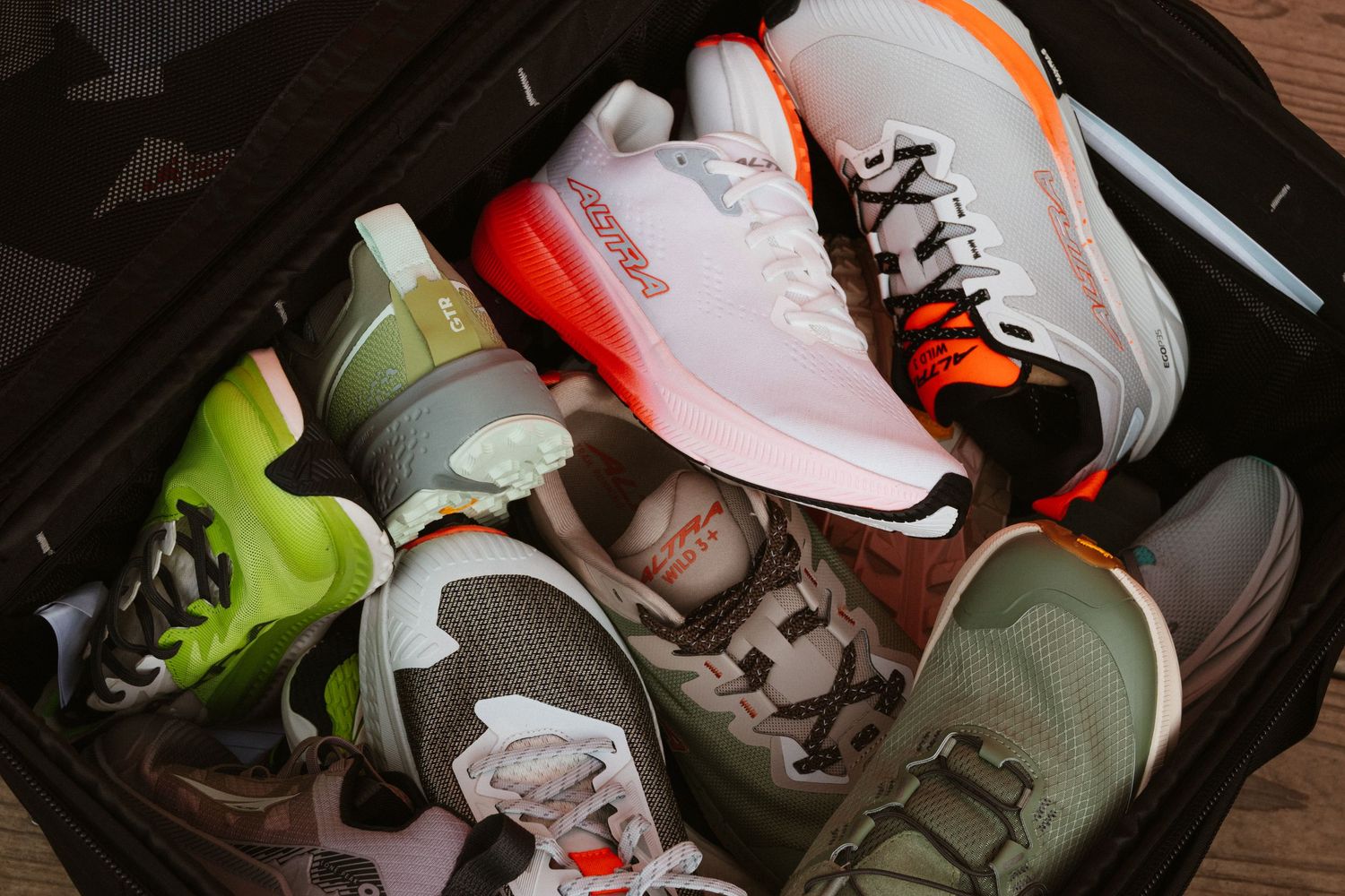Colorful collection of athletic sneakers packed neatly inside an open suitcase for travel.