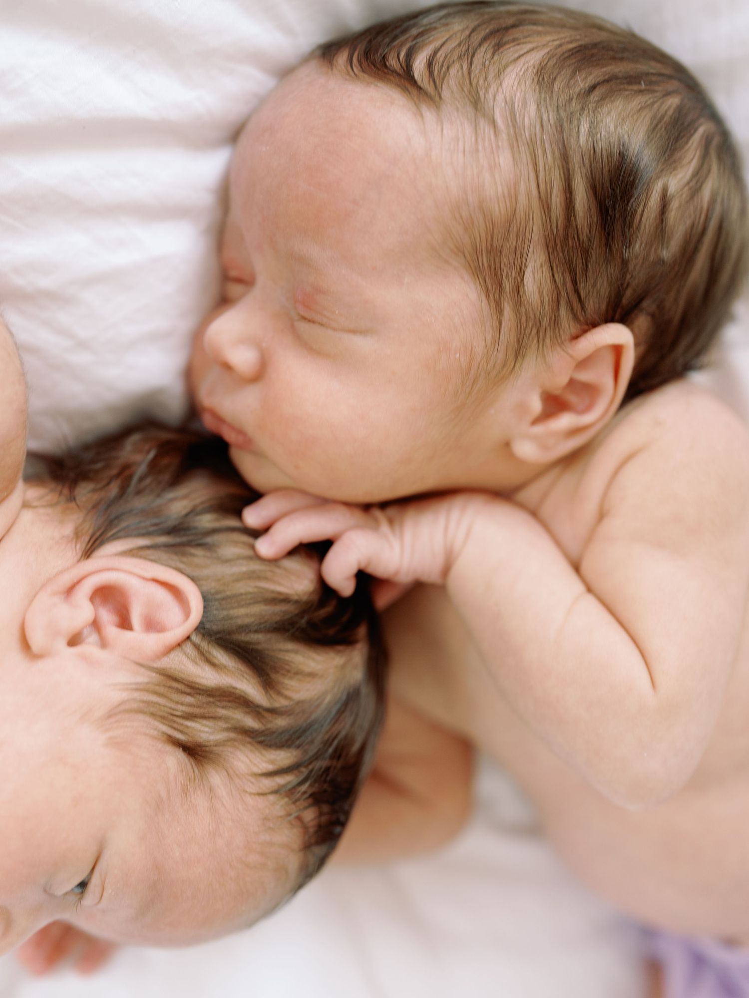 Newborn twins cuddled together during an in-home newborn session in Dallas