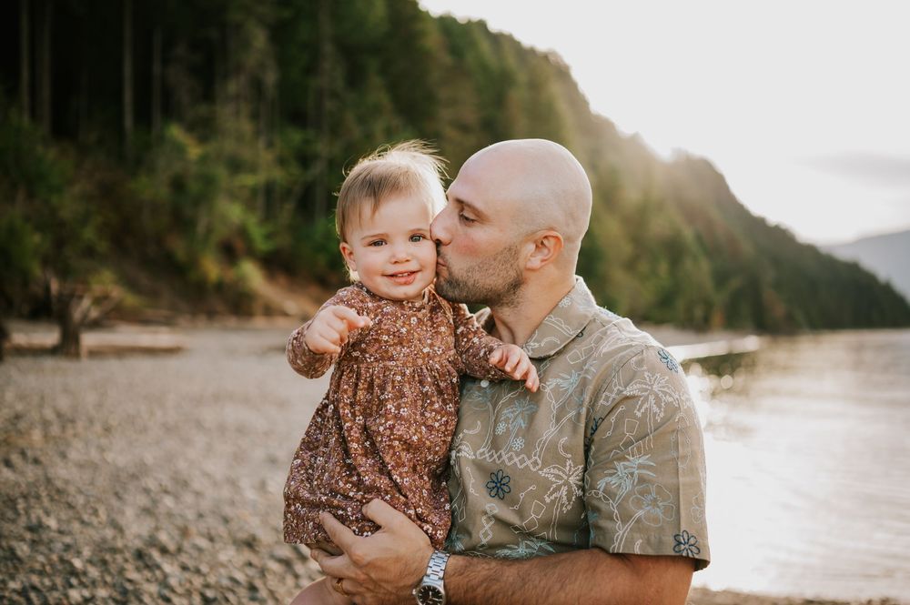 Comox Valley Photographer Portraits at Comox Lake in Cumberland, Vancouver Island. Casual and candid family photos dad kissing kid