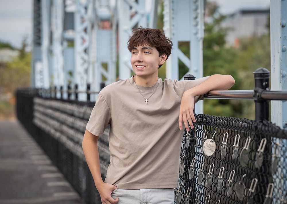 Senior photo of Spokane boy young man on a bridge in Riverfront park by Luba Wold photographer