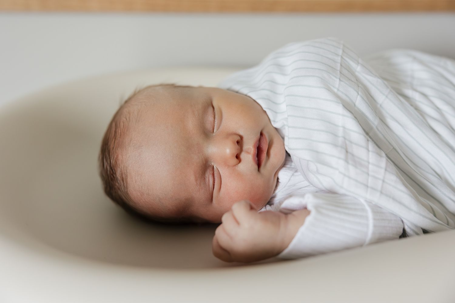 kansas city newborn photographer taking photo of sleeping baby laying on changing table