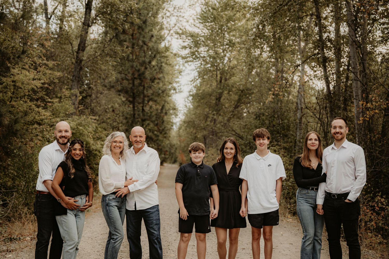 Extended family portrait on a tree-lined path in autumn.