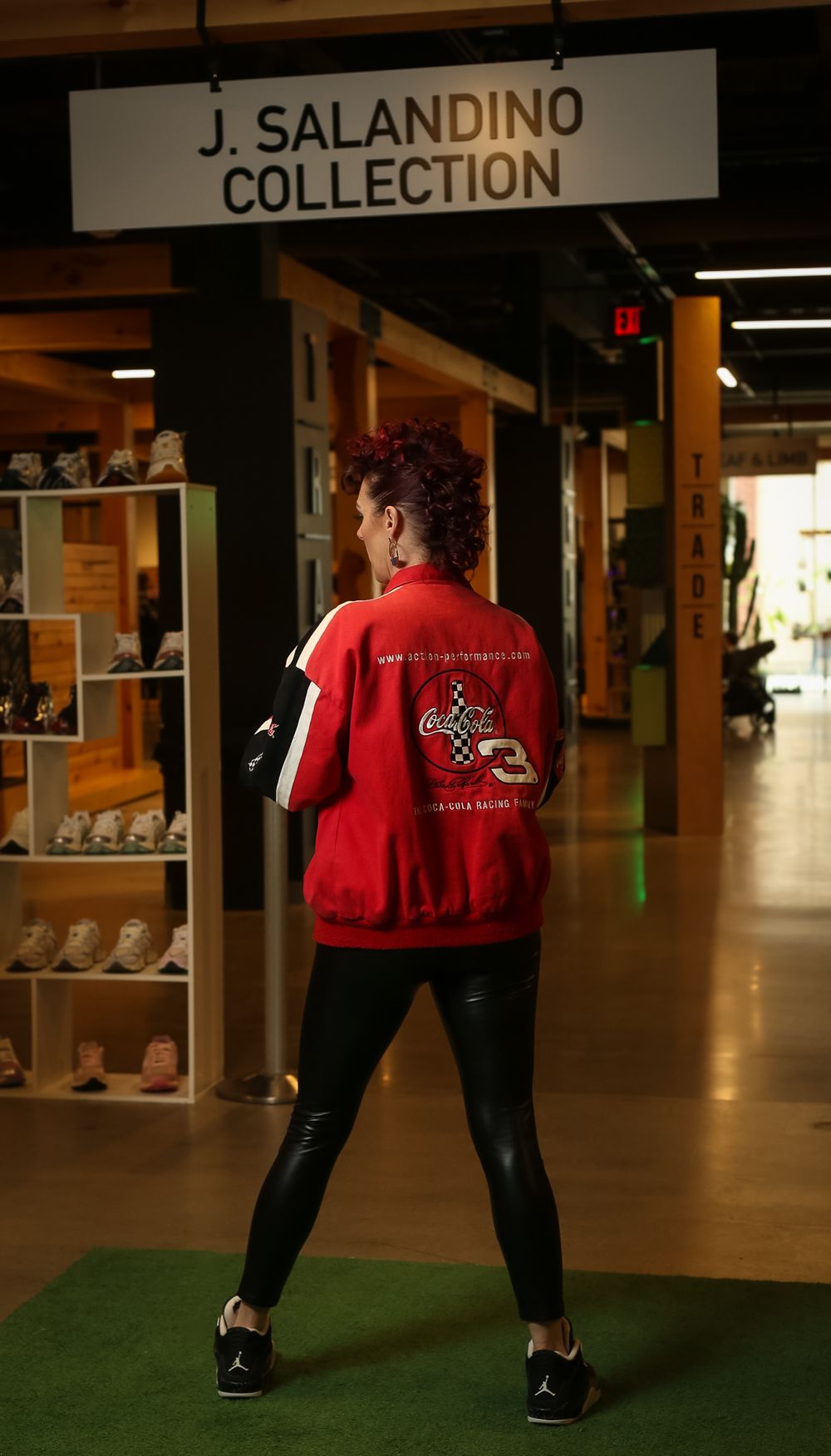 Someone wearing a red sports jacket with a logo stands in front of the J. Salandino Collection display in a store.