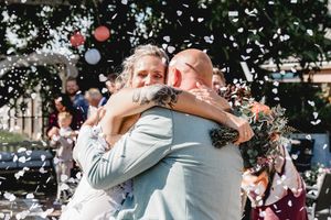 Candid outdoor wedding celebration moments with guests and greenery.