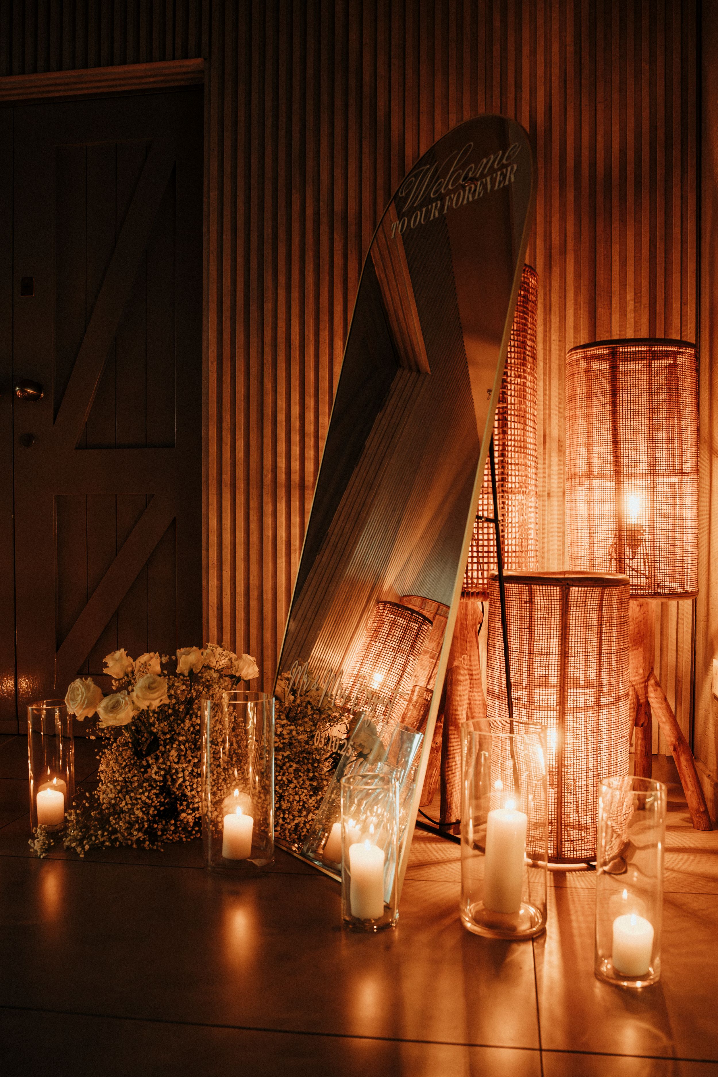 Romantic candlelit scene with crystal lanterns and white flowers creating a warm, intimate atmosphere in dimly lit space.