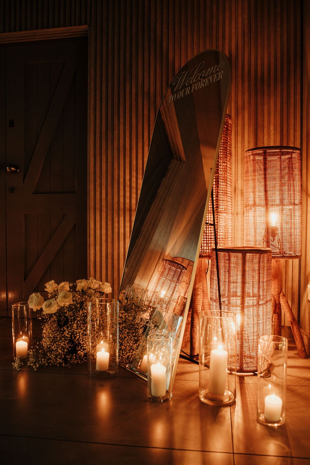 Romantic candlelit scene with crystal lanterns and white flowers creating a warm, intimate atmosphere in dimly lit space.
