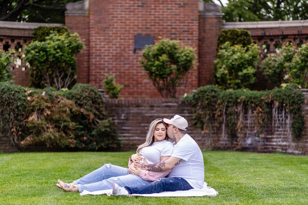 Romantic couple photos in a garden setting with brick walls and lush greenery creating an intimate outdoor atmosphere.