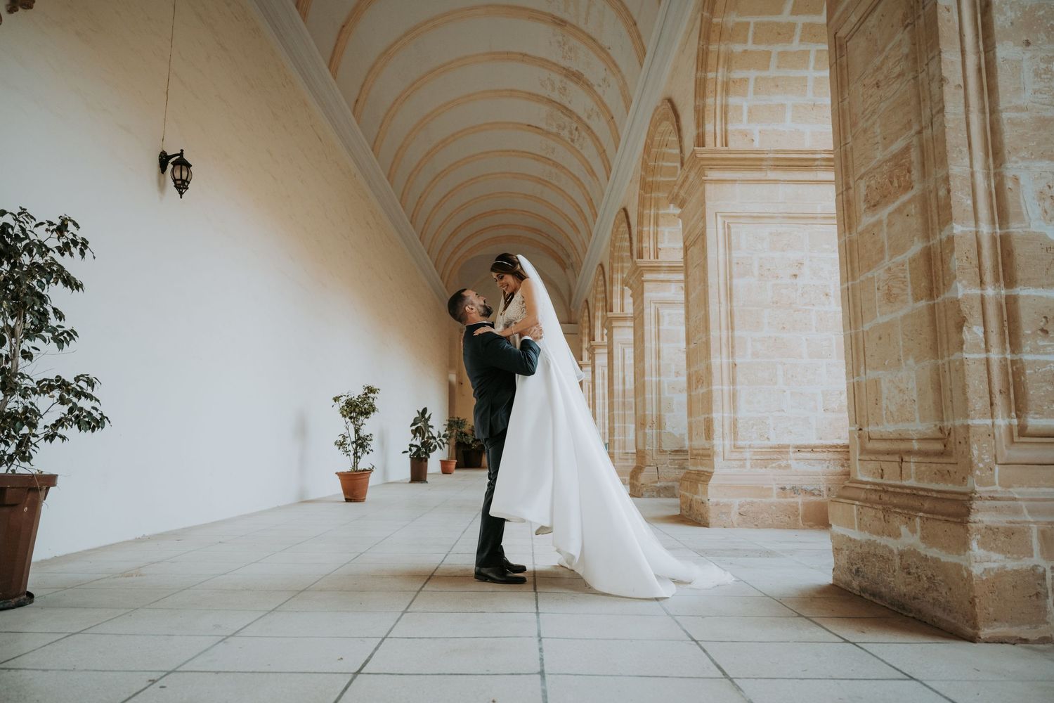 Elegant stone archway corridor with vaulted ceiling and natural lighting.
