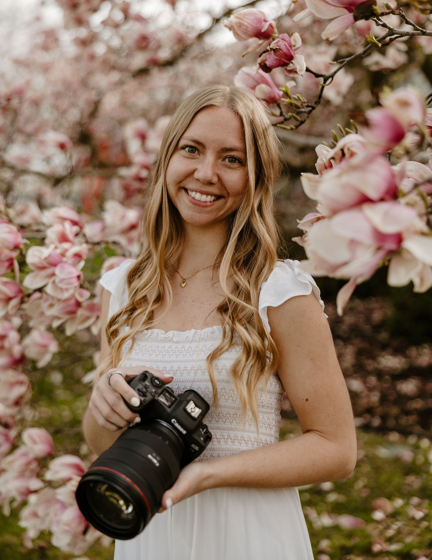 A young woman stands in a lush garden surrounded by trees and wildflowers on a sunny day. Fort Worth Texas photographer.