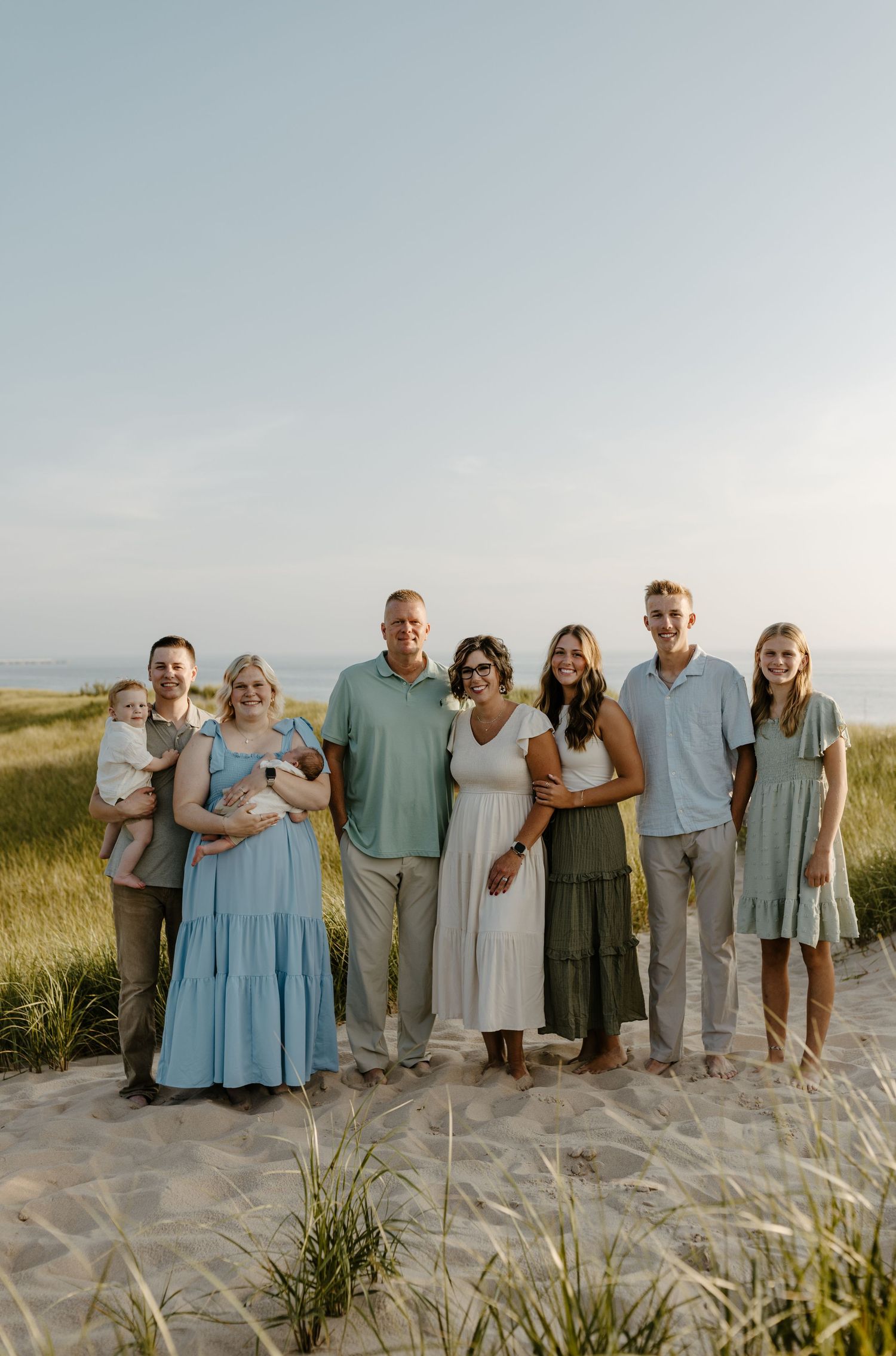 A group of people, including adults and children, standing in a field with a scenic background. Fort Worth Texas family photographer.