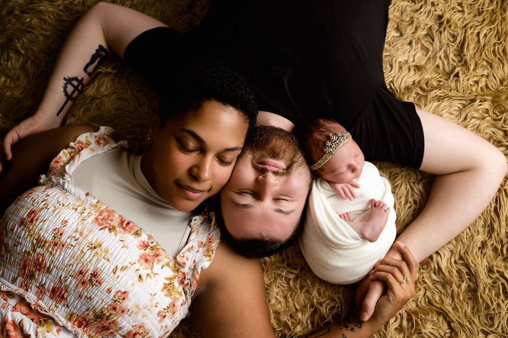 Two people lying close together on a textured golden surface in matching floral print outfits.