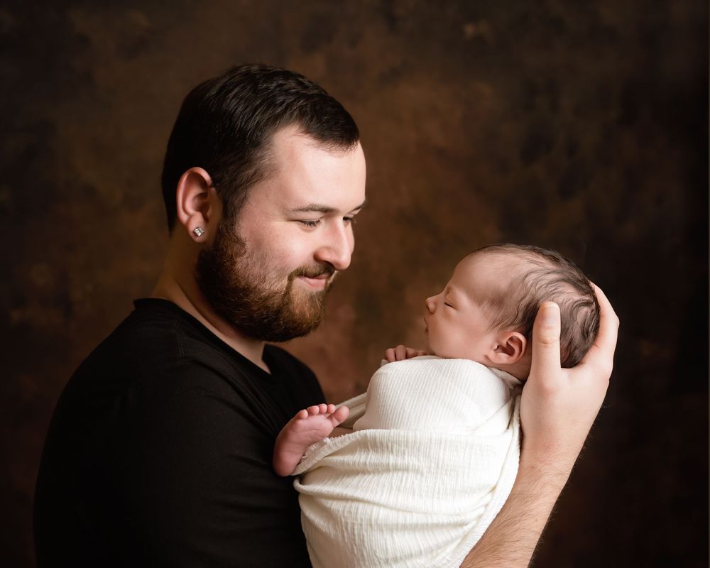 A series of intimate black and white photographs showing tender moments between parent and newborn.