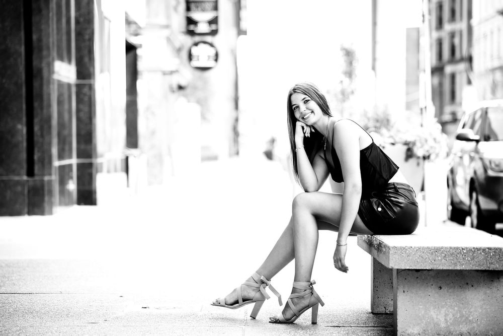 A black and white photo series showing a woman in various elegant dance-like poses against urban architecture.