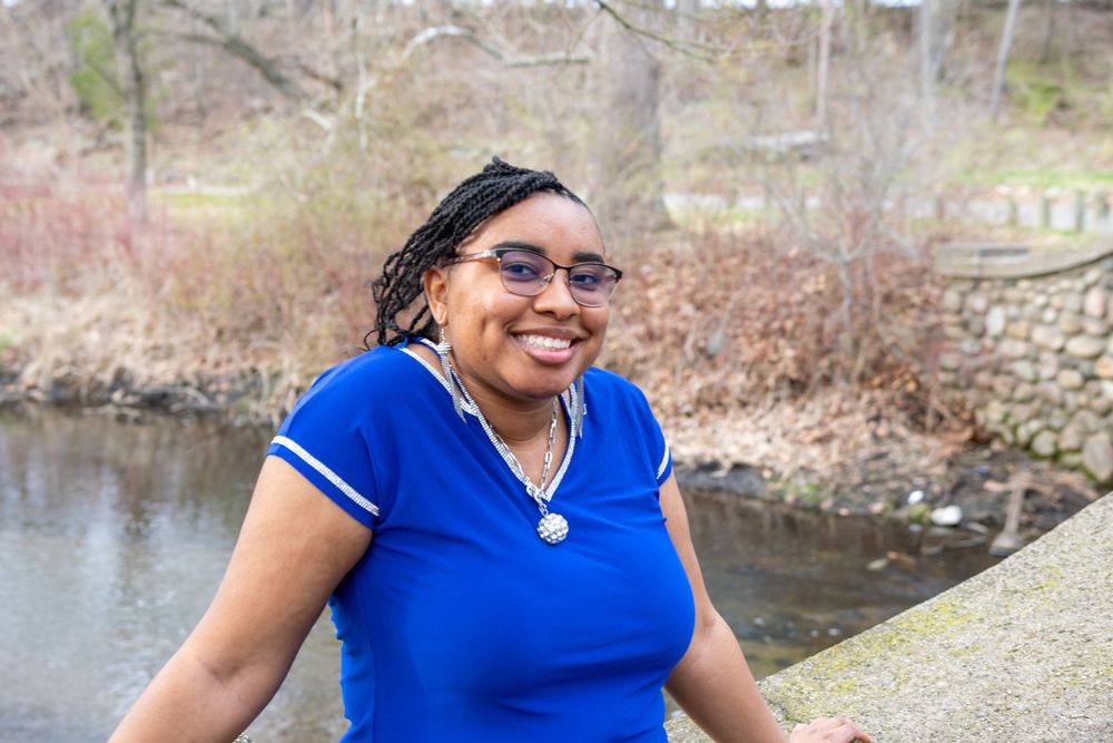 Casual portraits taken near a pond with bare trees in the background.