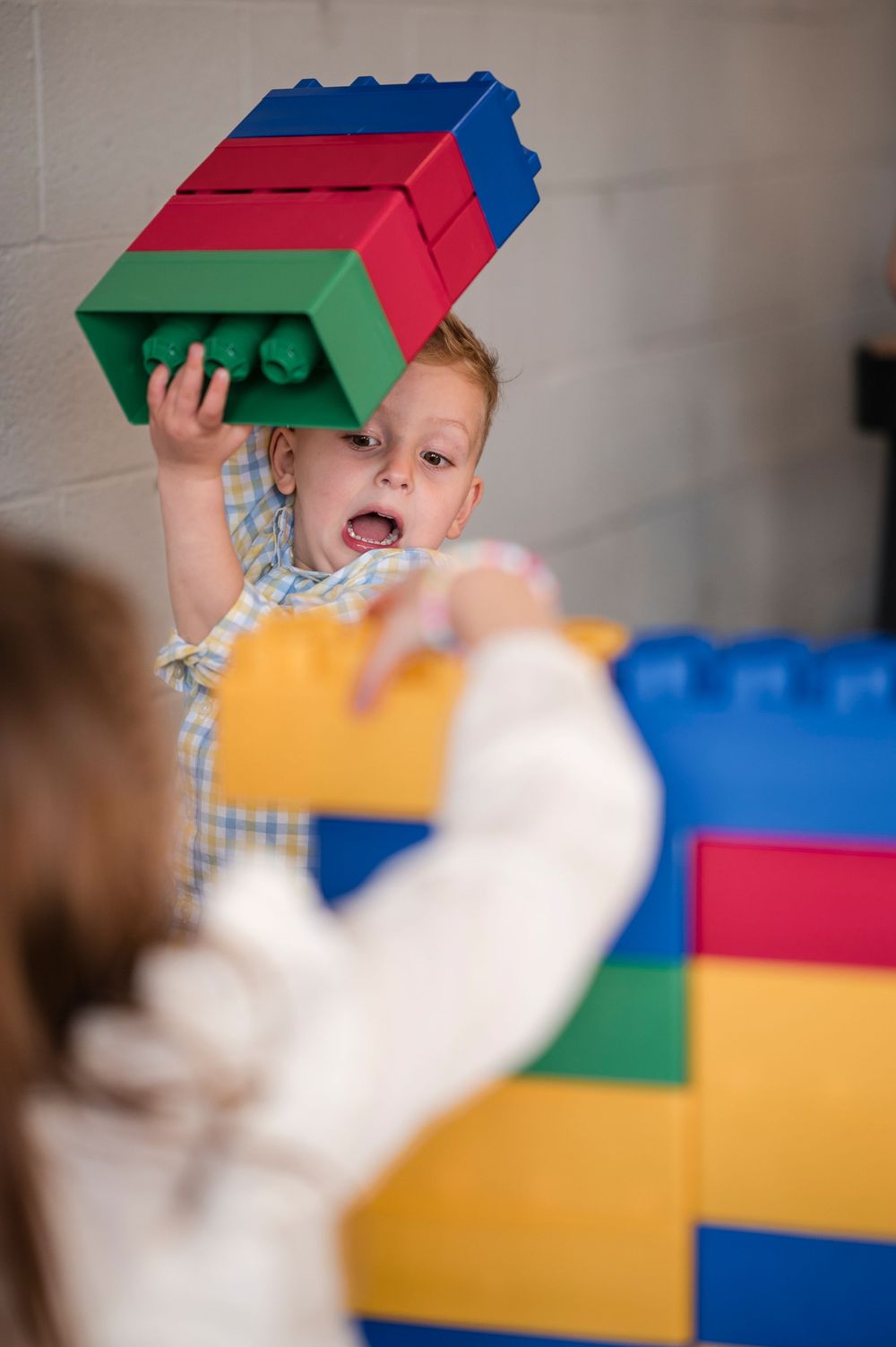 Colorful plastic building blocks being stacked and played with in a creative learning environment.