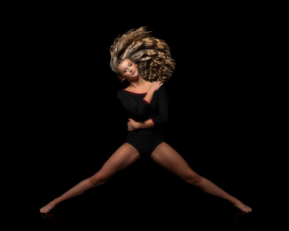 A dancer in black attire strikes a dramatic pose against a dark background, creating an artistic silhouette.
Pittsburgh Dance Photographer