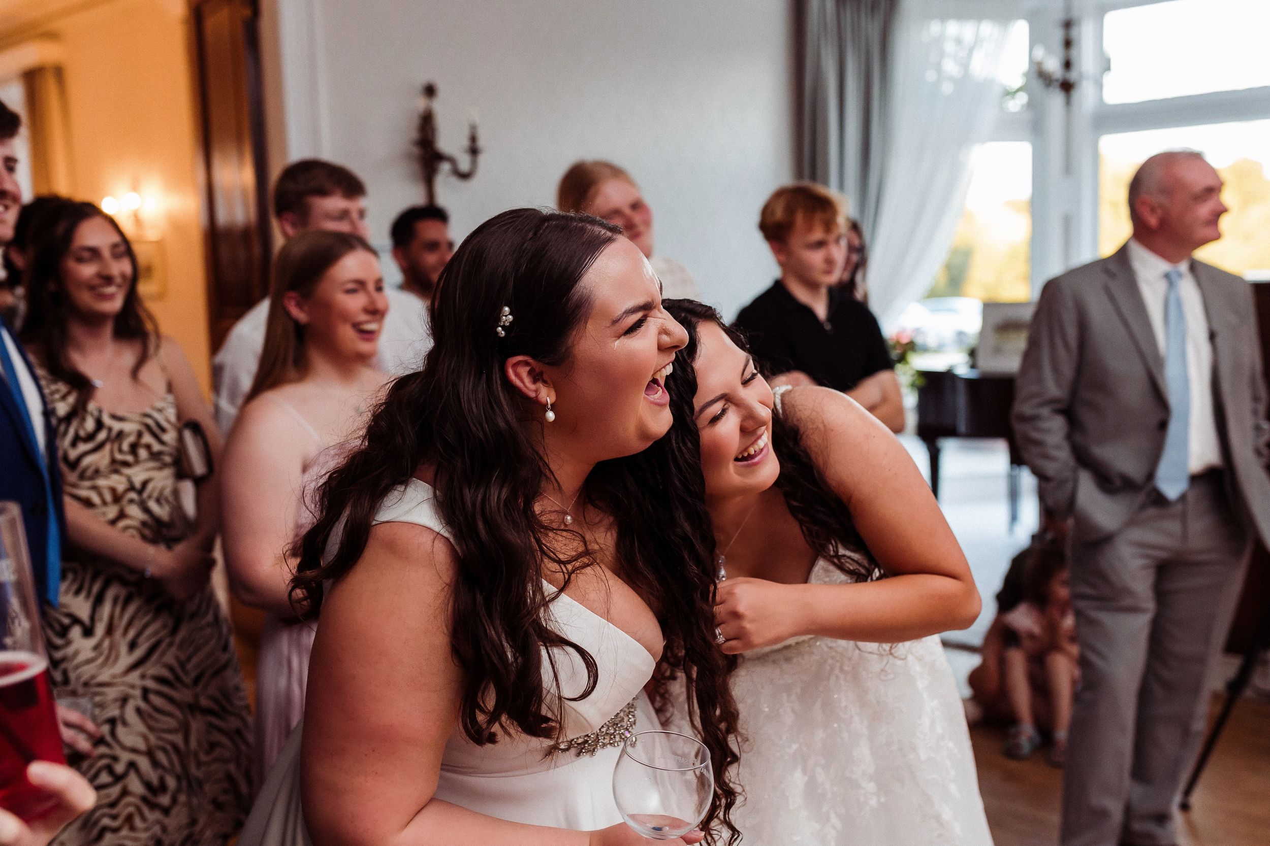 People laughing and having fun at a formal event with smiles and joyful reactions.