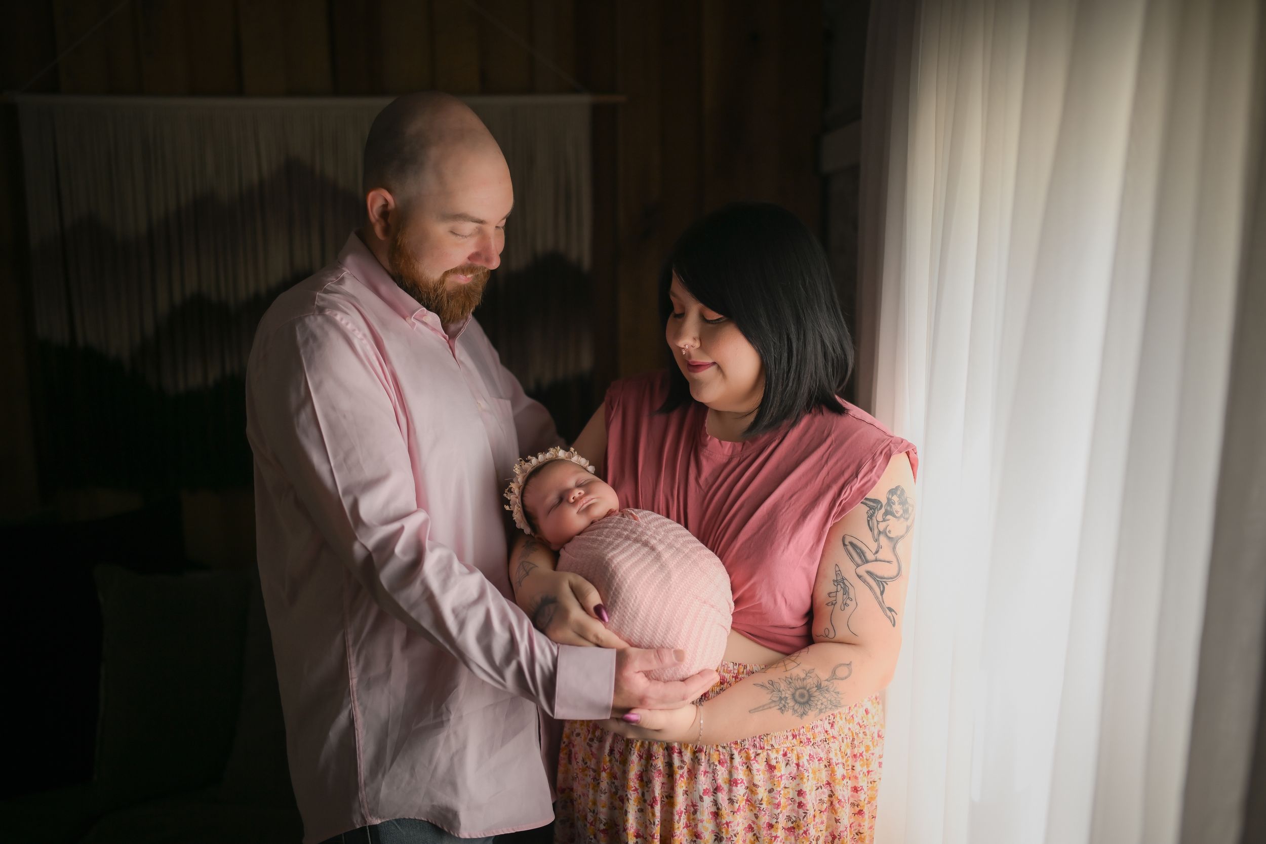 Family portrait by window with soft natural lighting.