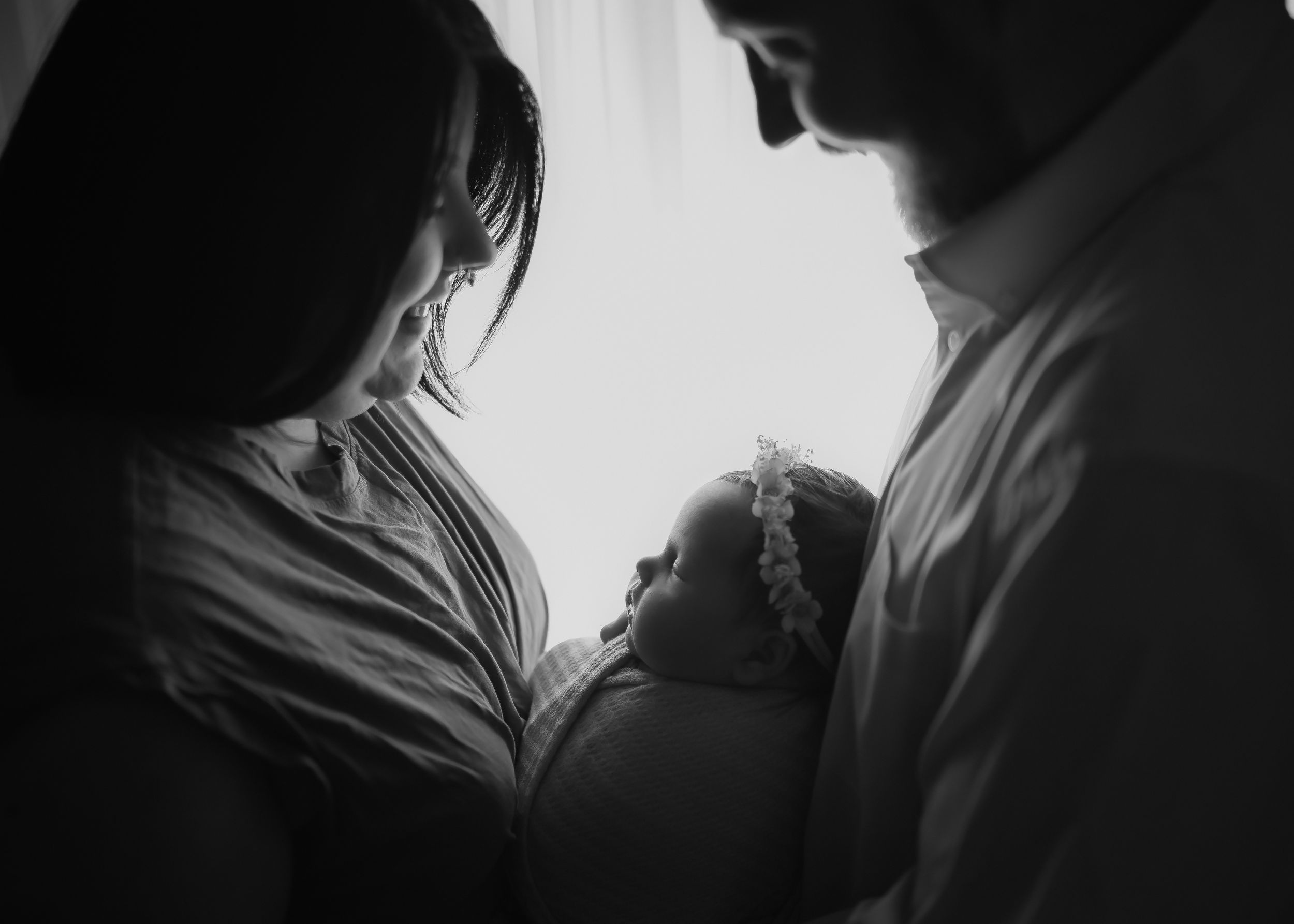 Silhouetted figures in intimate black and white portraits showing tender moments.