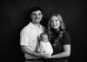 Black and white studio portrait with dramatic lighting.