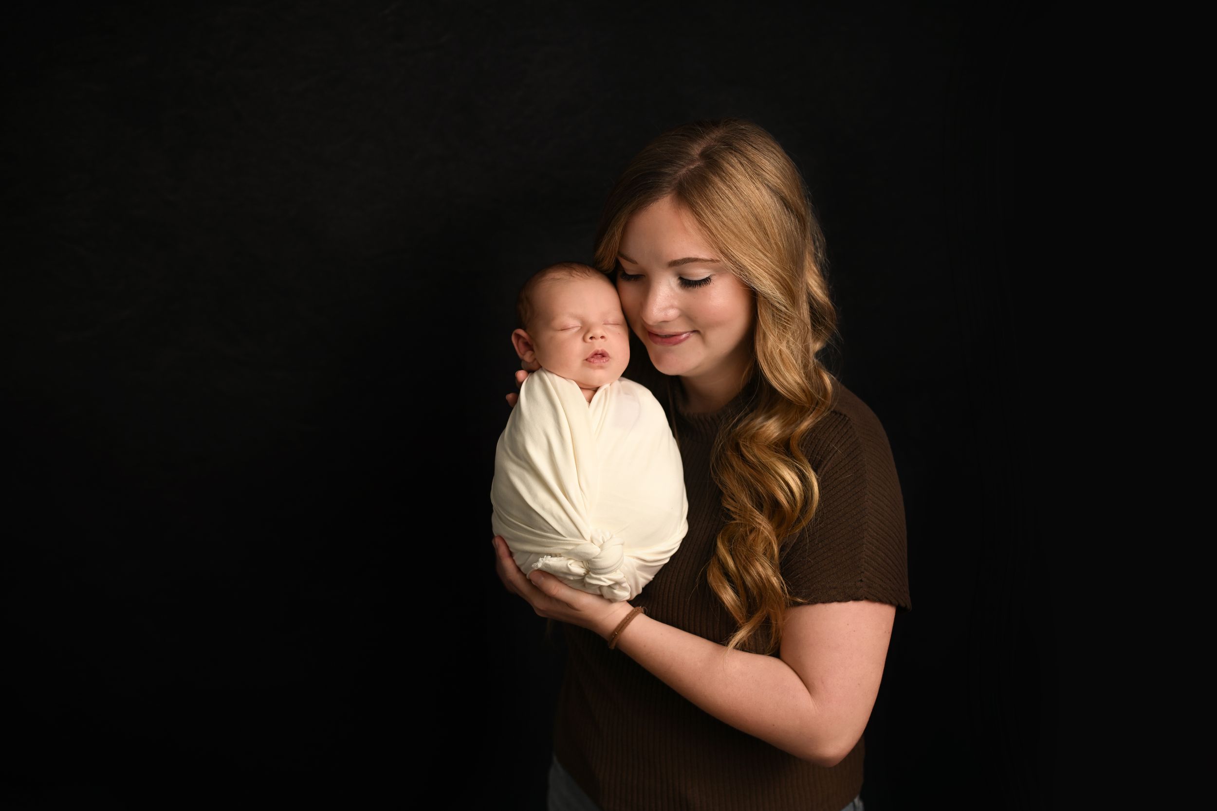 Studio portrait against black background with soft lighting.