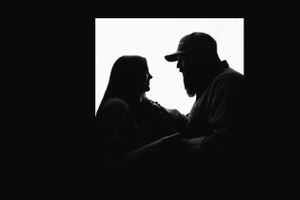 A series of silhouette portraits showing intimate family moments against a black background.