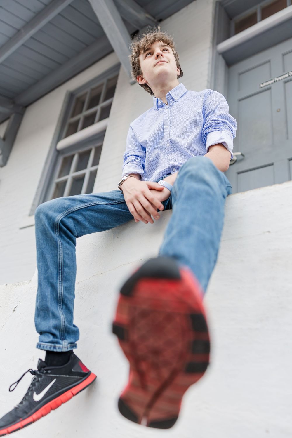 A sequence of four photos showing red and black Nike sneakers against a white wall with denim jeans.