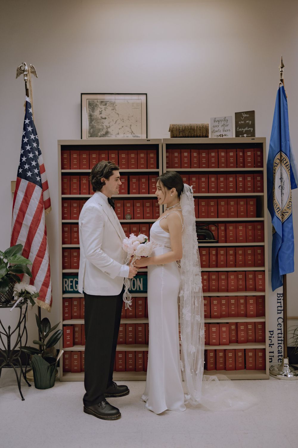Wedding ceremony sequence in front of American flag and law books in official government setting.