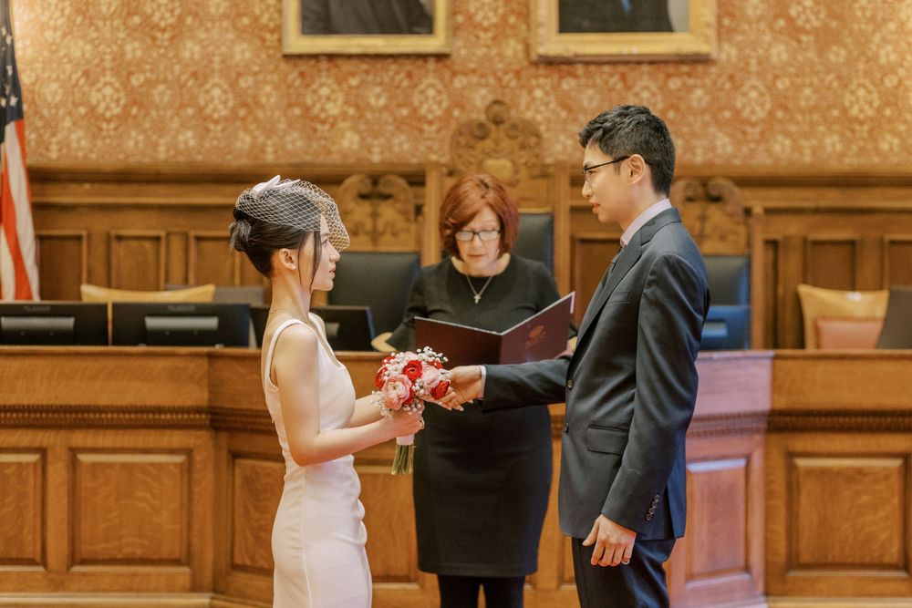 Wedding ceremony candid moments in an elegant historic building interior.