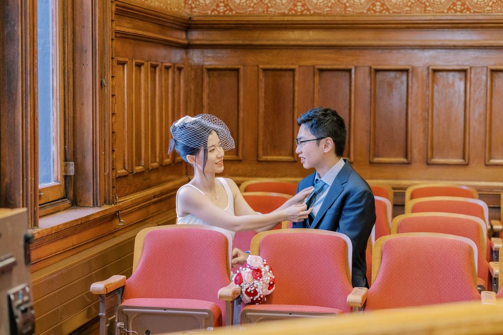 Wedding couple photographed in an elegant wood-paneled room with ornate decor.