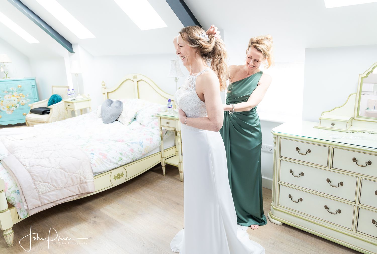 A wedding dress being fitted in an elegant bedroom with antique furniture.