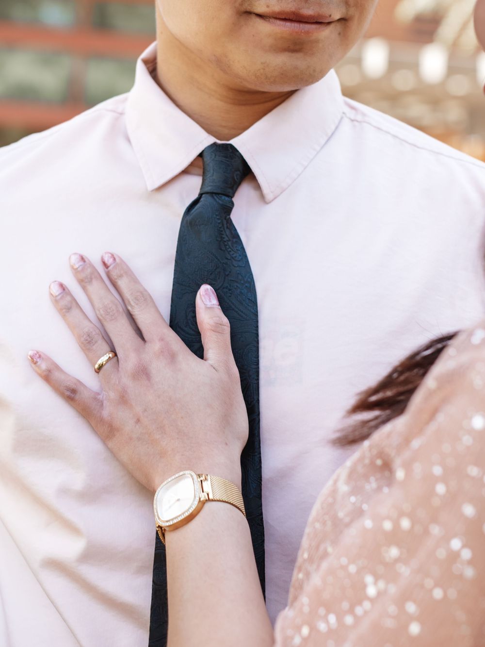 A close-up shot showing hands adjusting a navy blue tie against a crisp white dress shirt.