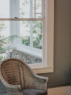 Vintage wicker chair by bright window with white trim and natural light.