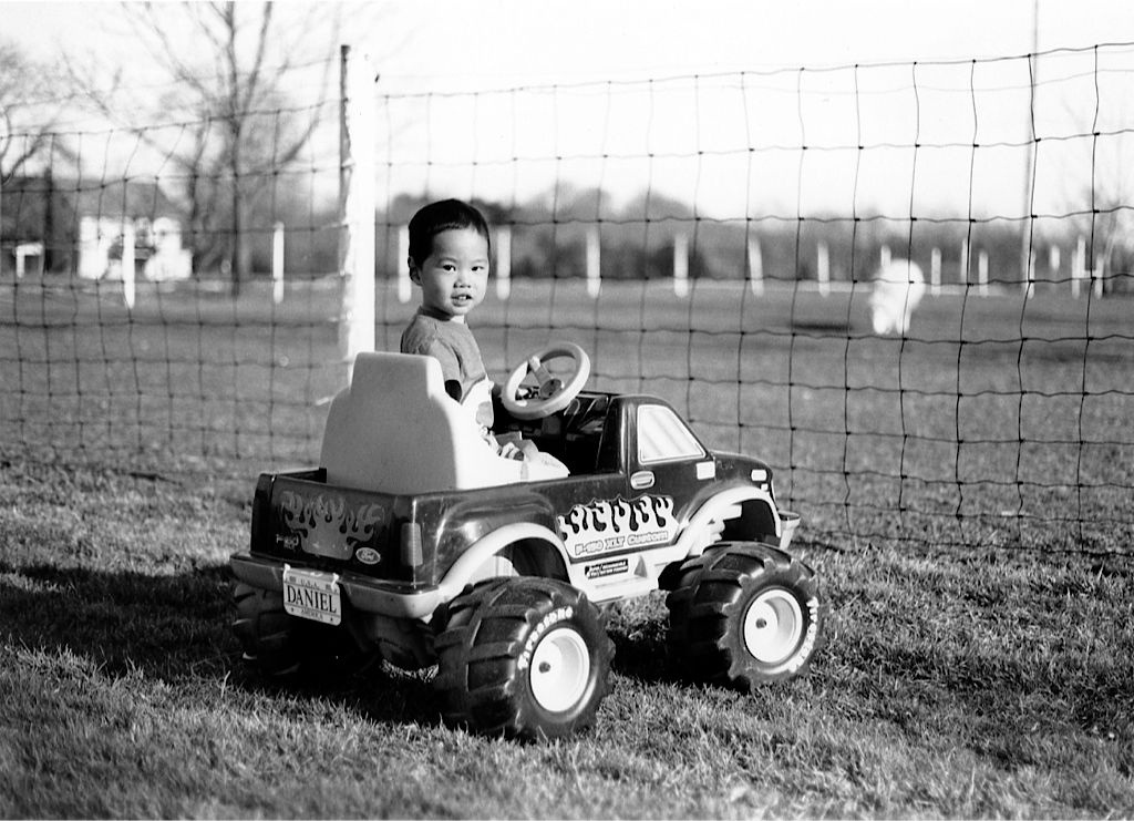 young boy riding toy car