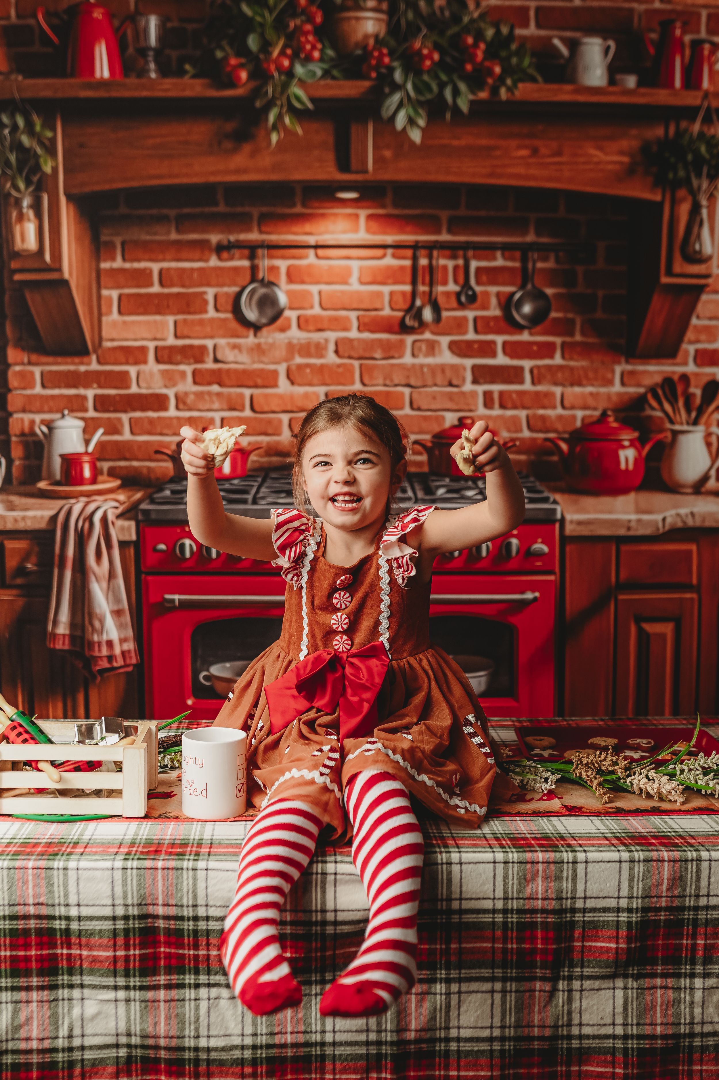 Playful holiday scene with striped stockings and plaid tablecloth in a rustic brick kitchen.