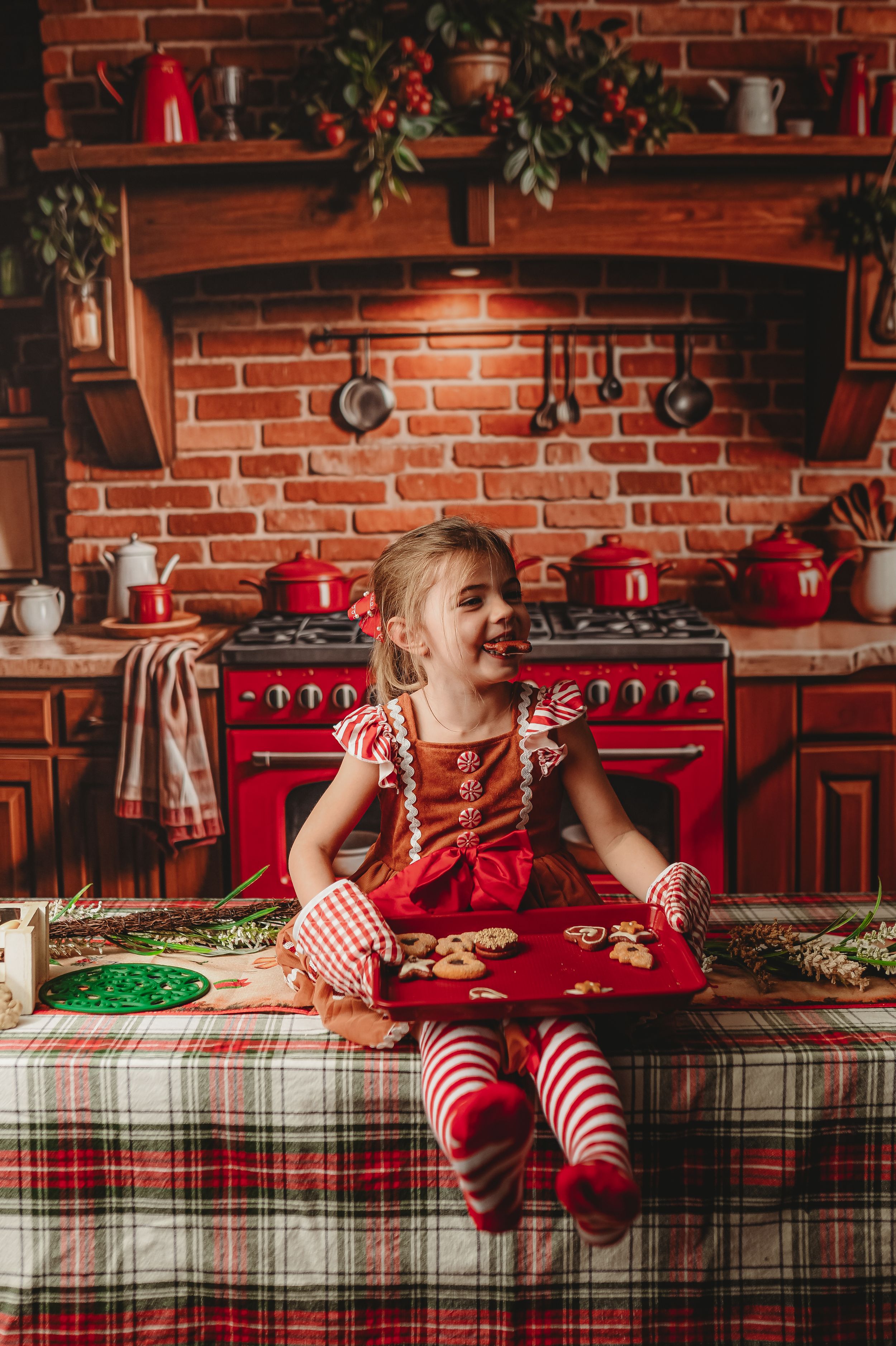 Holiday baking scene with gingerbread cookies on plaid tablecloth in vintage-style kitchen.