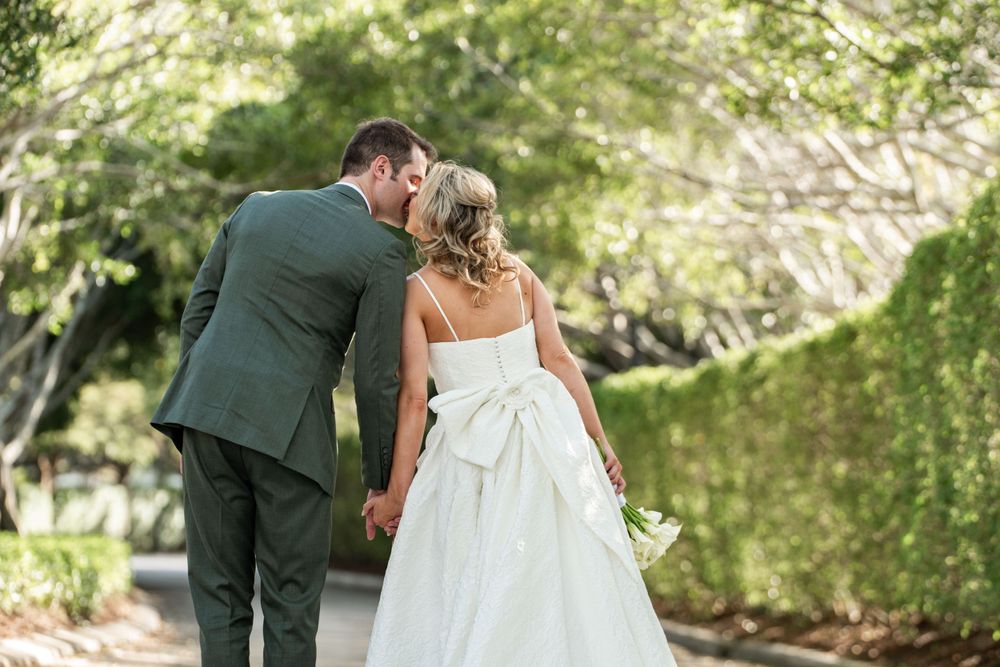 bride and groom kissing green forrest background