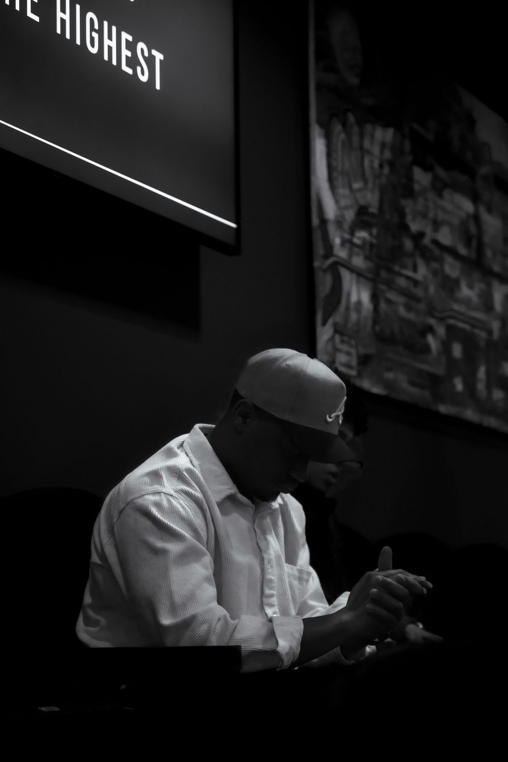 A person in a white chef's coat works in a dimly lit professional kitchen setting.