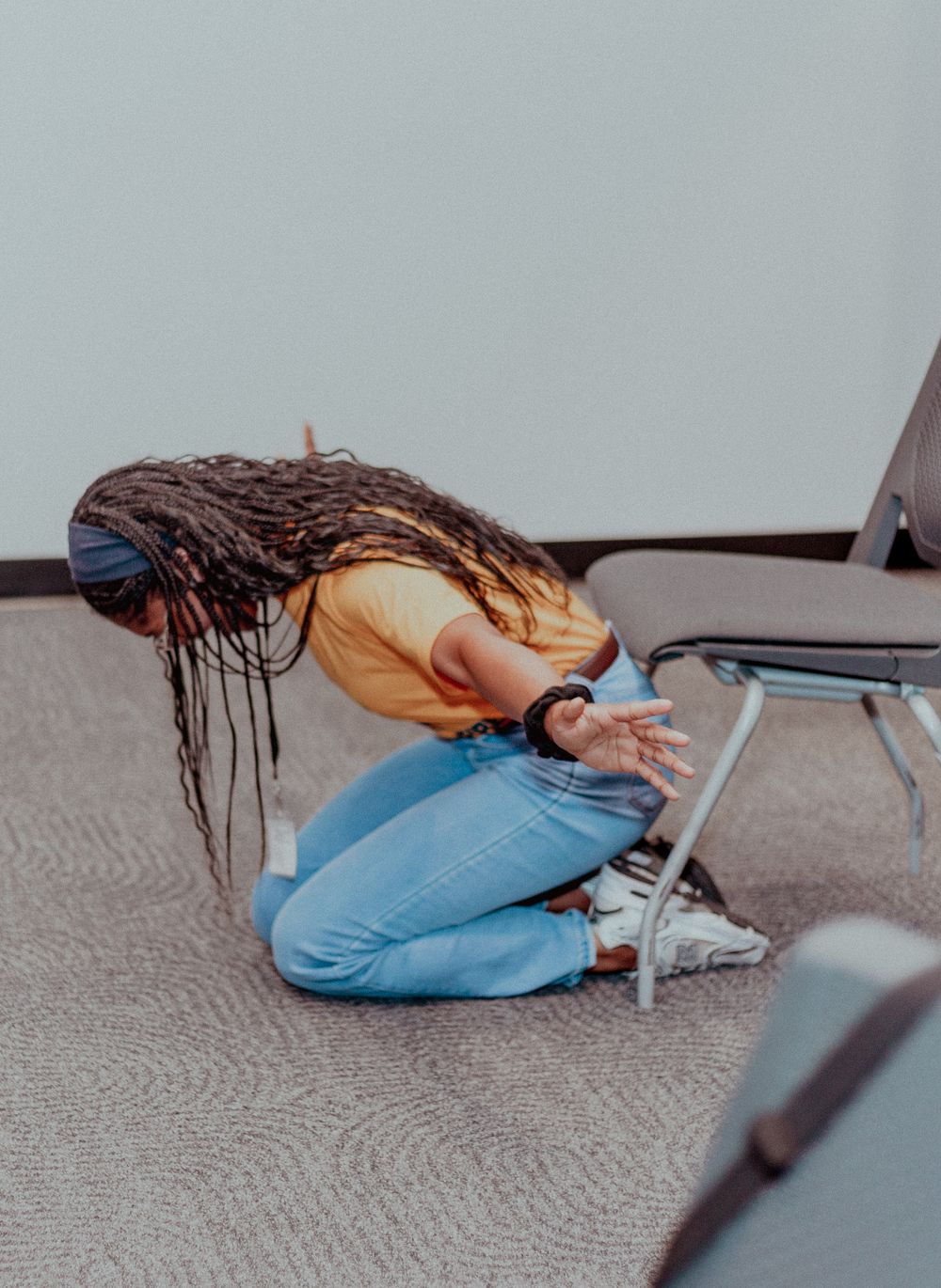 Person in blue jeans lying on carpet demonstrates different positions for floor stretching exercises.