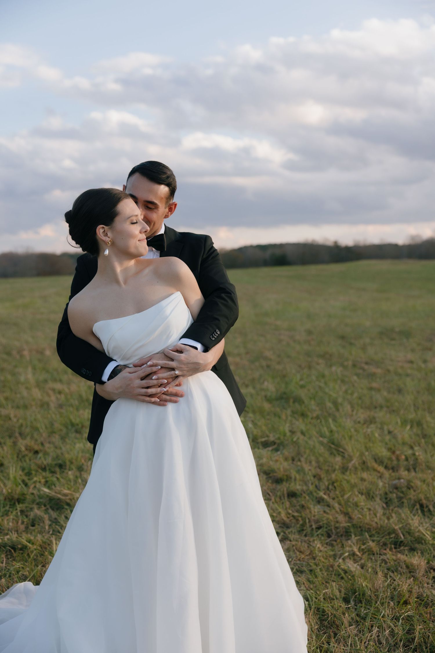 A newlywed couple walks under a wooden arch during their outdoor garden ceremony.