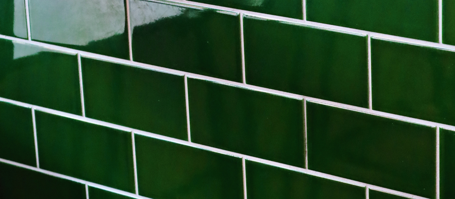 Green subway tile pattern creating a geometric background texture.