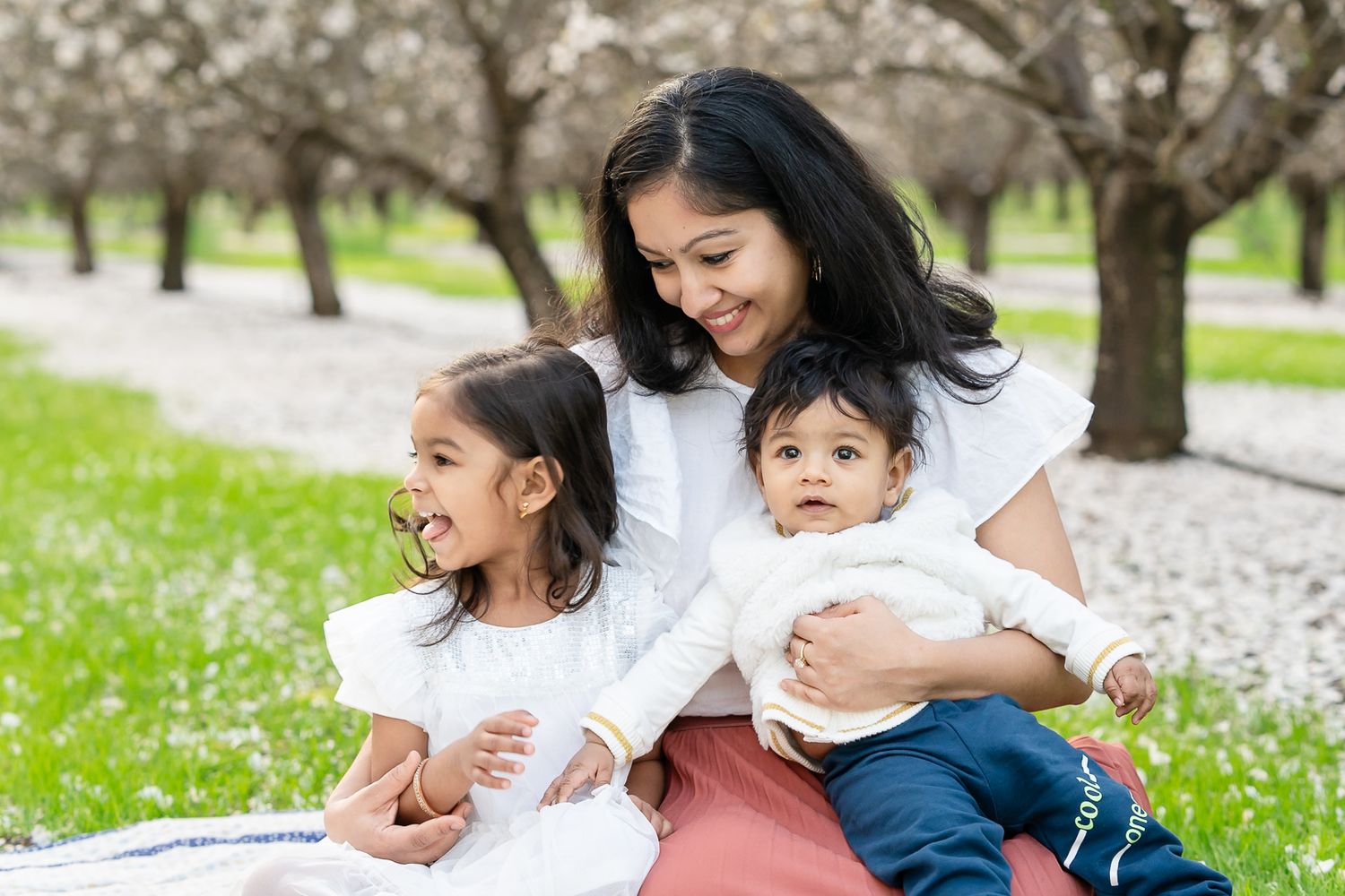 Sweet mother-daughter moment in Tracy, CA almond orchards. Light & airy family photography capturing love and connection
