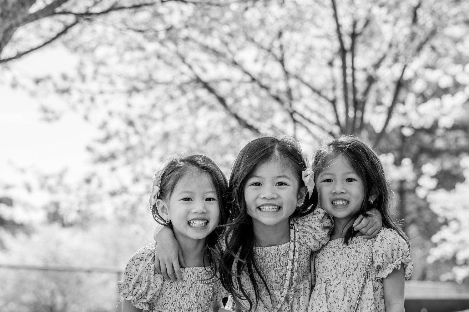 Group photo outdoors with cherry blossoms in black and white.