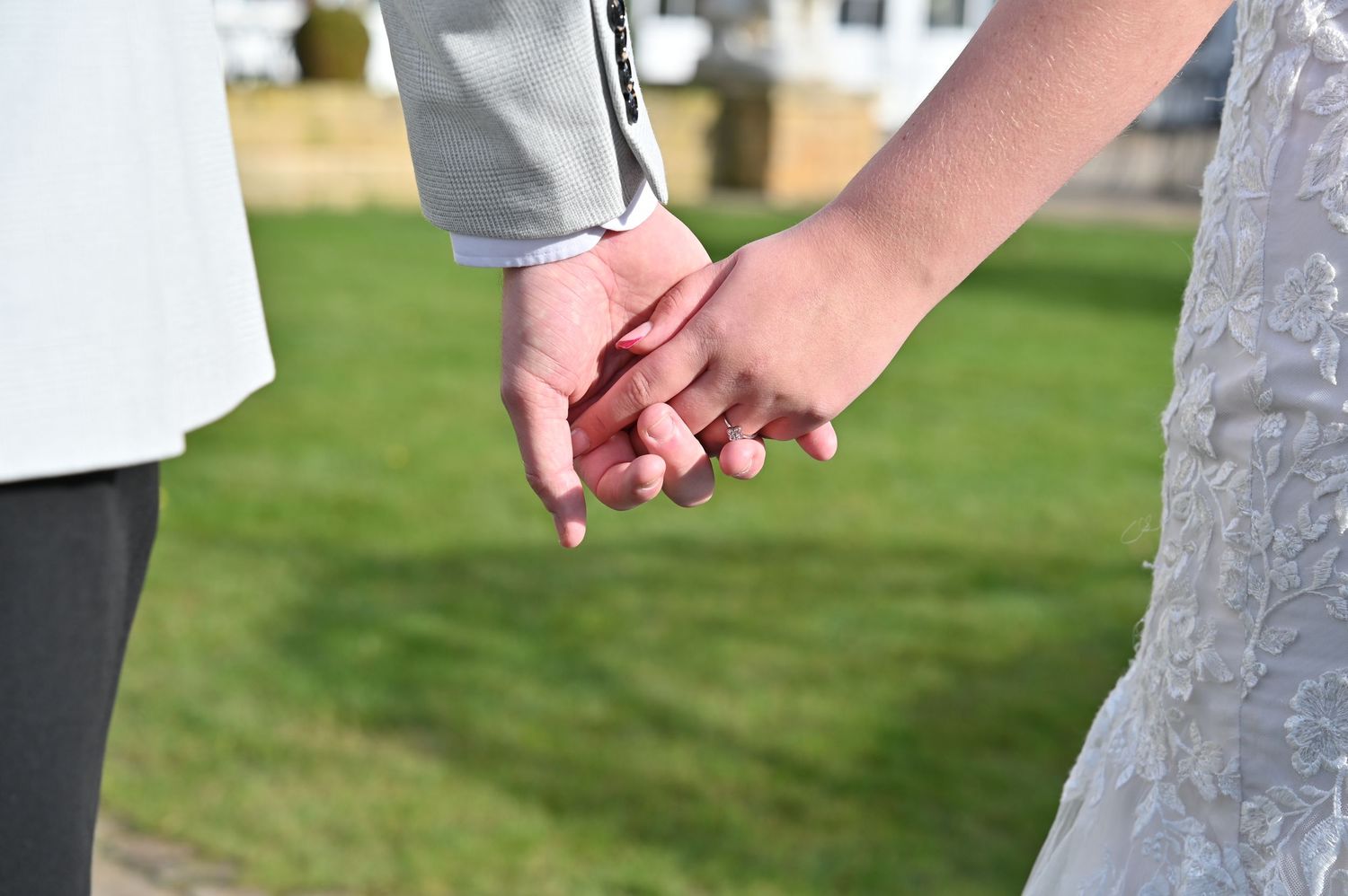 A happy couple poses together against wooden wall background outdoors.