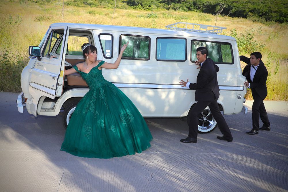 Classic white vintage van parked outdoors with emerald green formal dress.