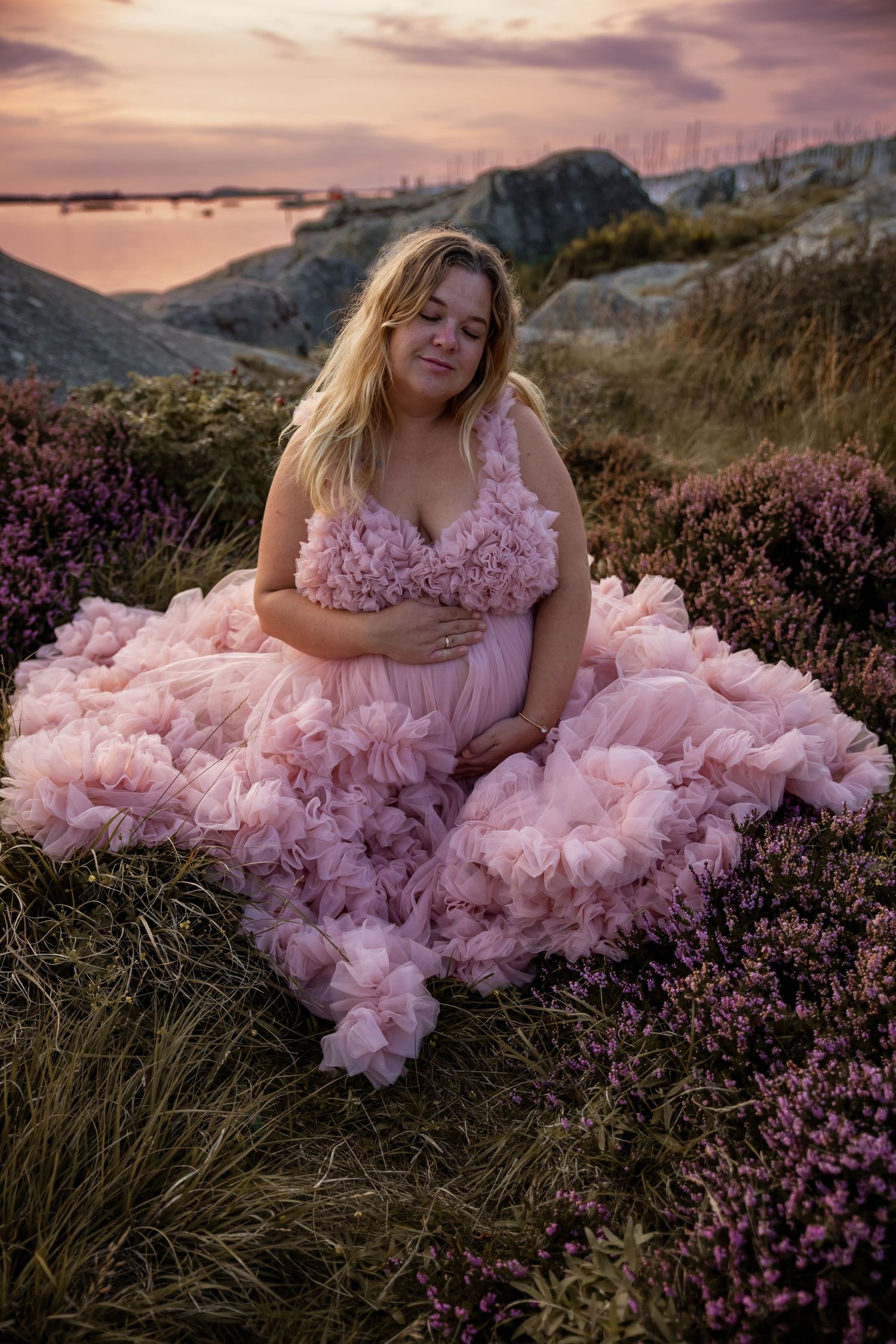 Sunset portrait featuring a pink tulle gown against purple heather and coastal views.