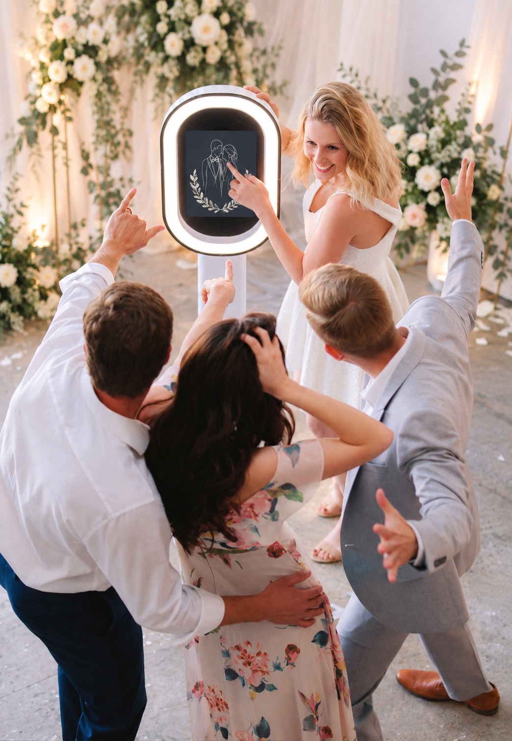 A large decorative mirror with neon pink "Touch Here to Start" text display and ambient lighting on a red carpet setup. 
Mirror Photo booth