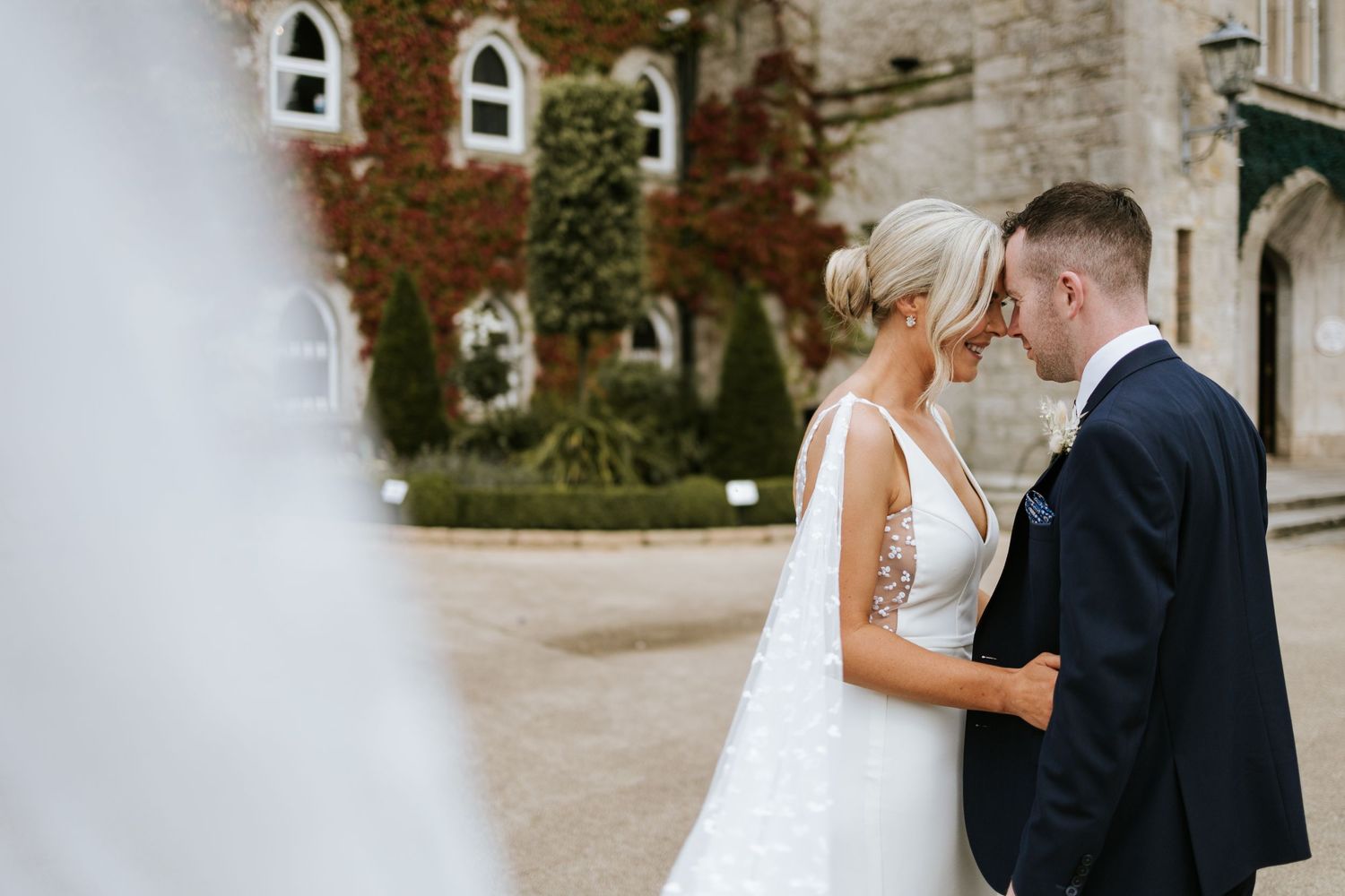 Classic wedding couple portraits at a historic stone church building with elegant architecture.